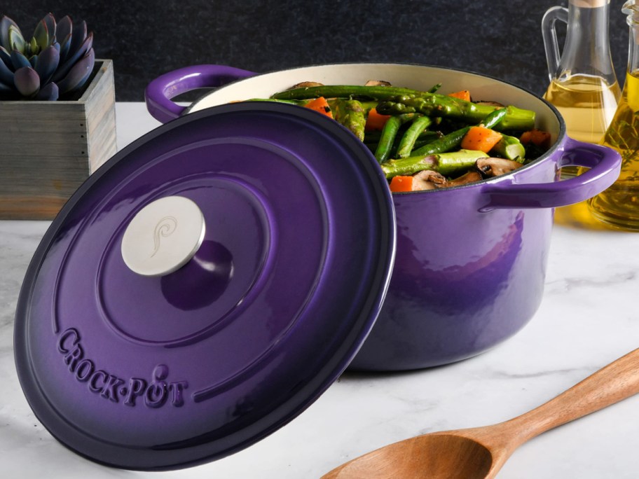 purple crock pot dutch oven with food in it