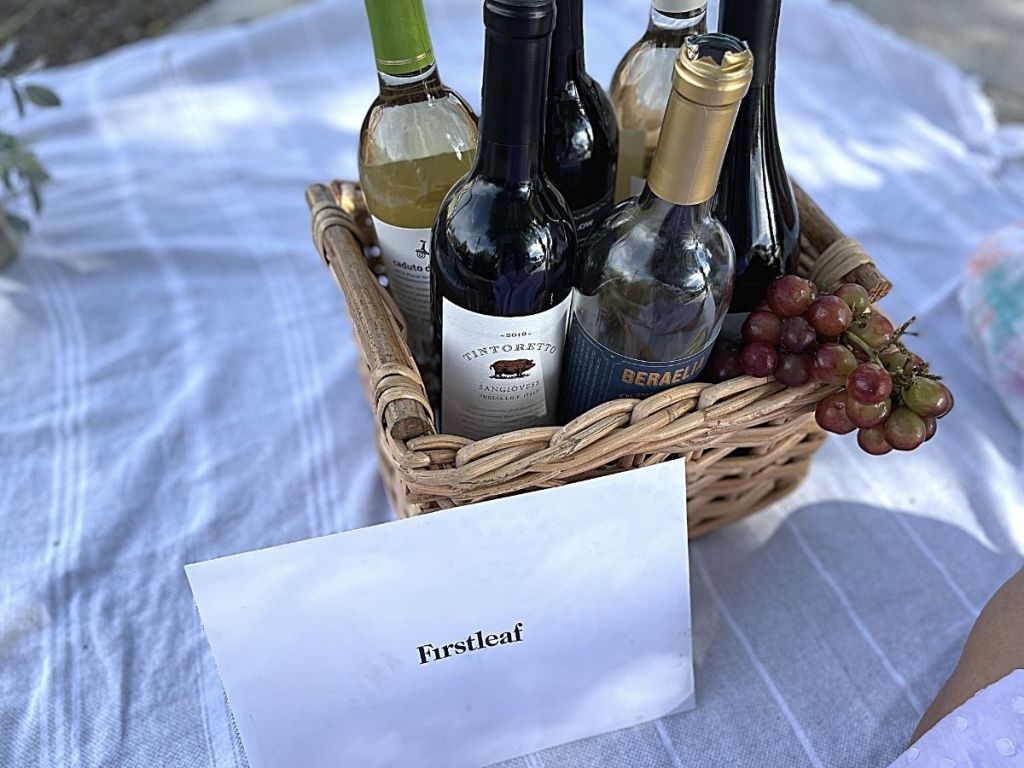 basket filled with bottles of wine and grapes