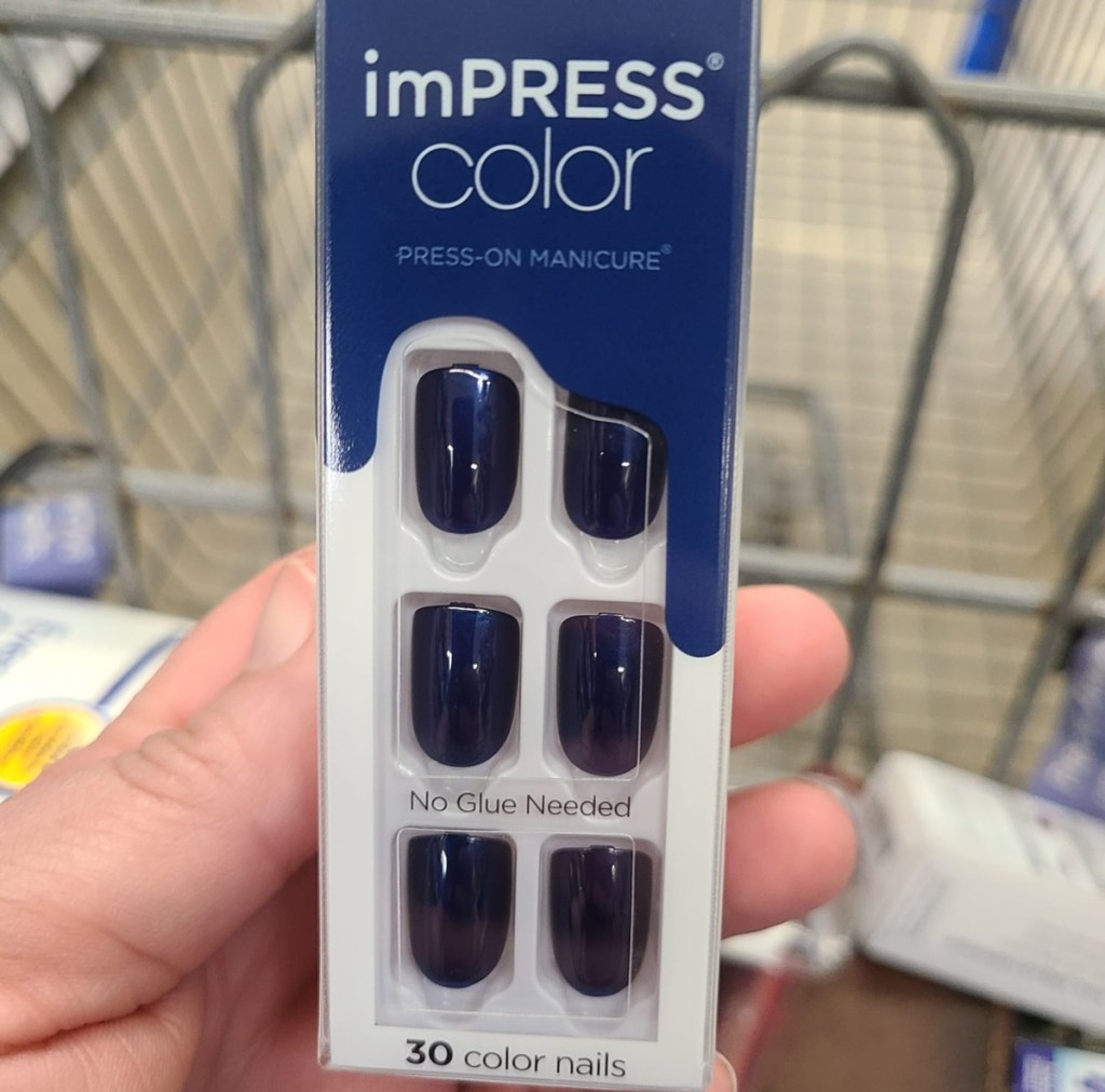 holding a set of blue press on nails