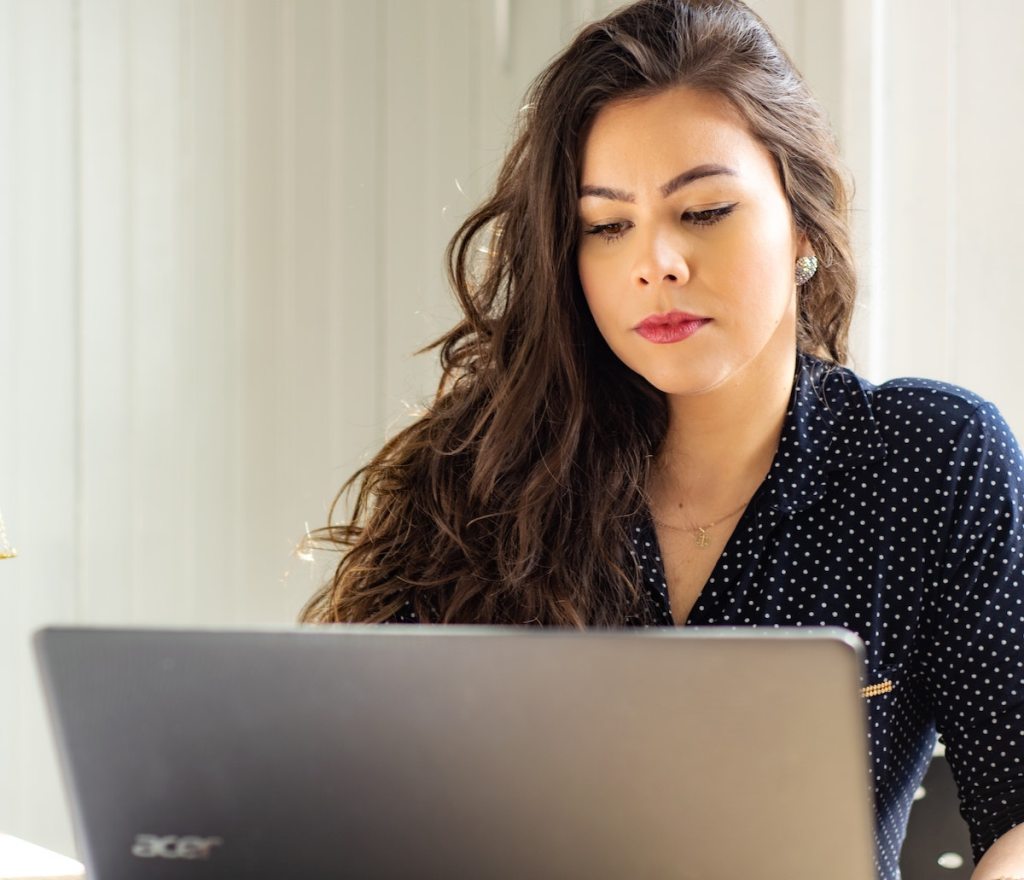 business woman sitting in front of laptop showing how some law firms have a teacher discount