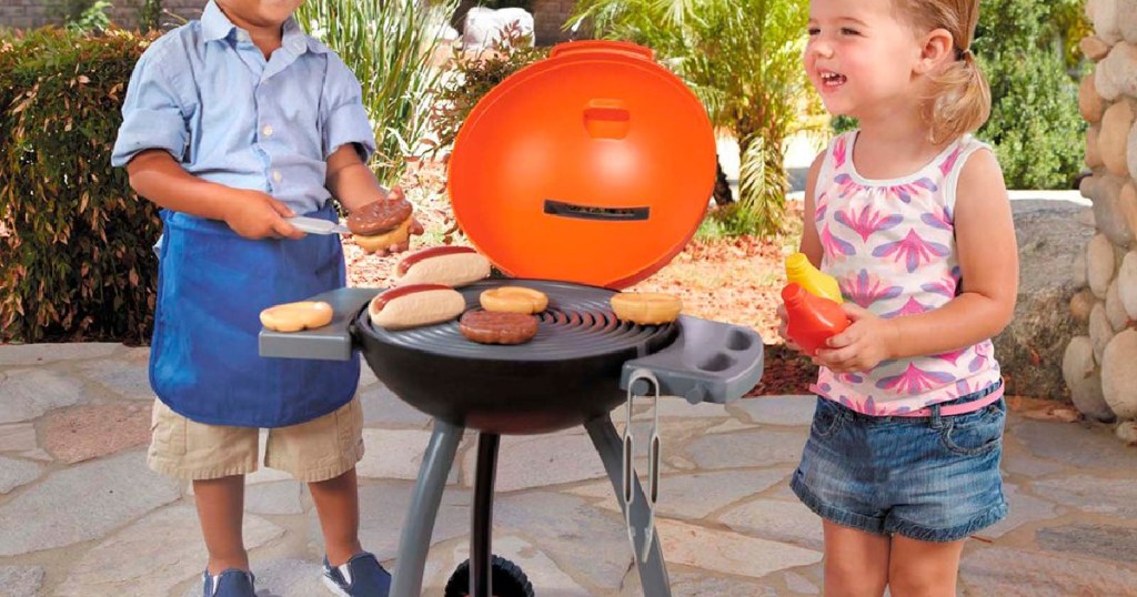 two kids playing with little tikes grill
