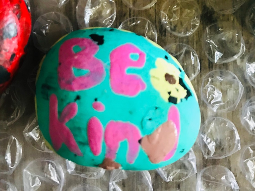 rock painted with words "be kind"