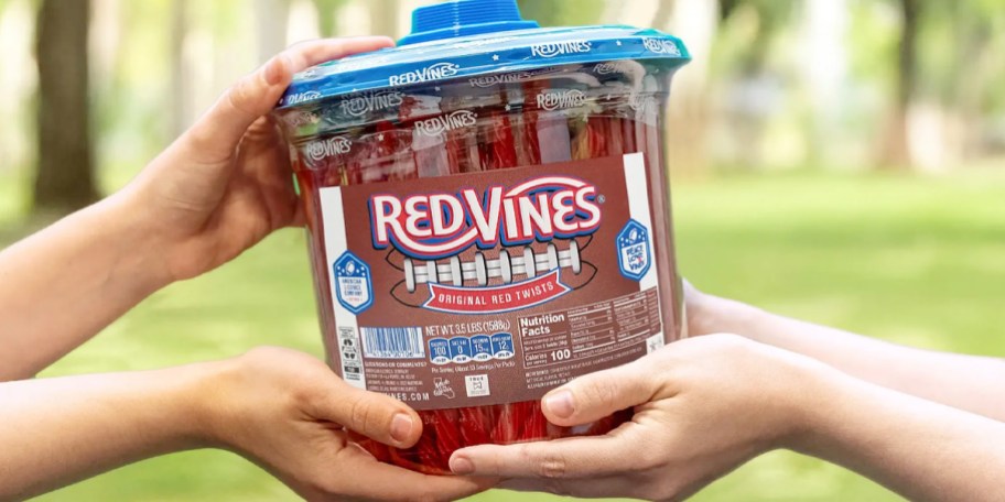 hands holding jar of red vines candy