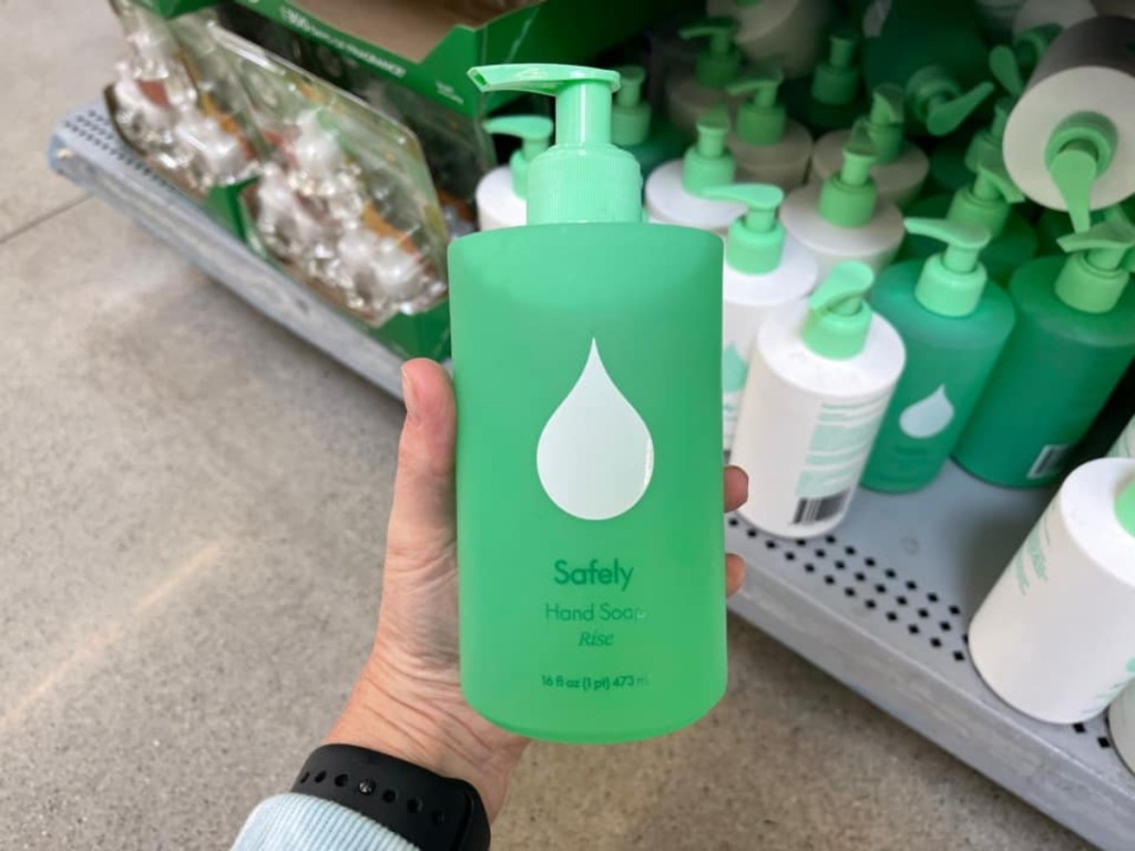 holding a green bottle of hand soap