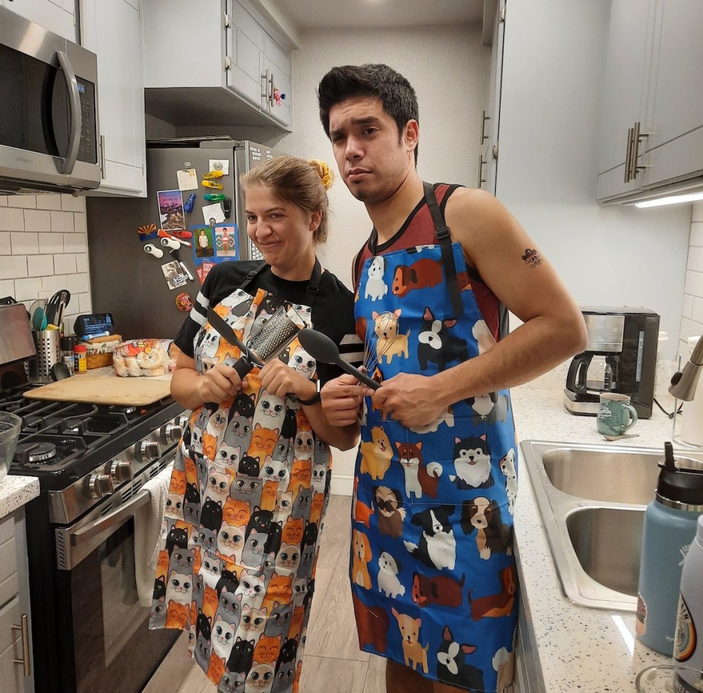 man and woman standing in kitchen wearing animal aprons