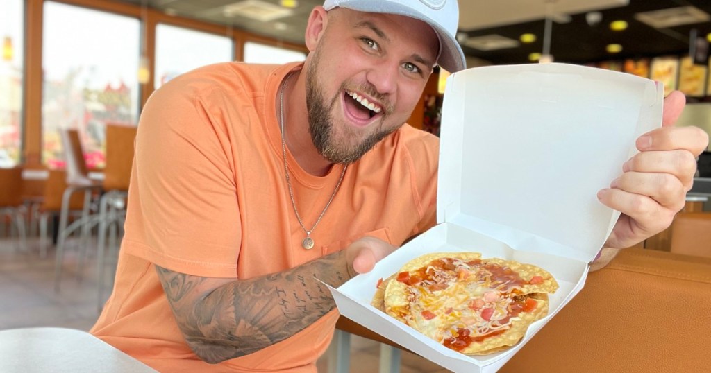 man showing a taco bell mexican pizza in a box