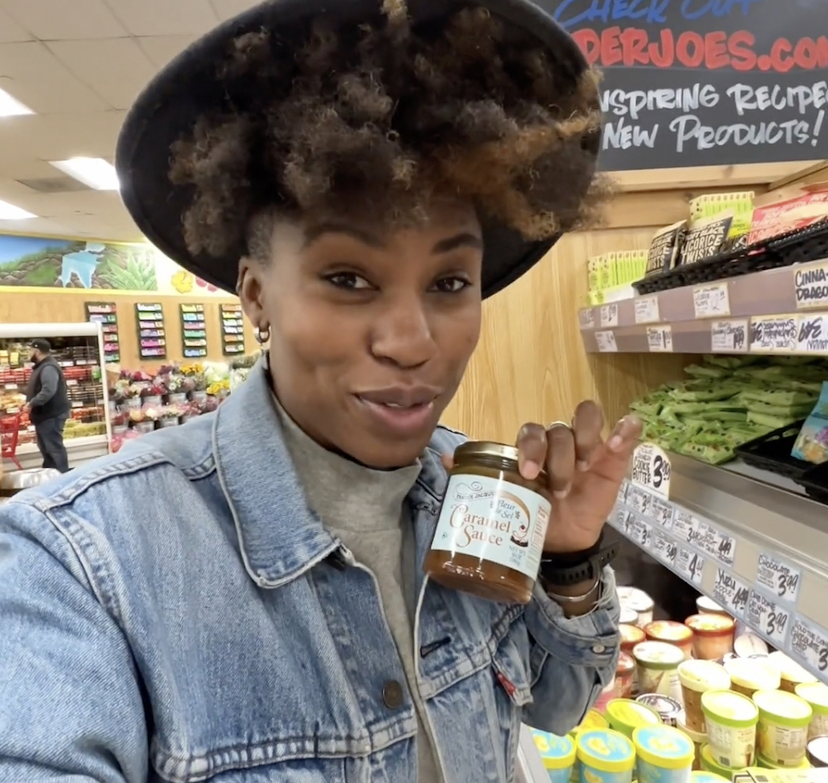 woman holding jar of caramel sauce in store