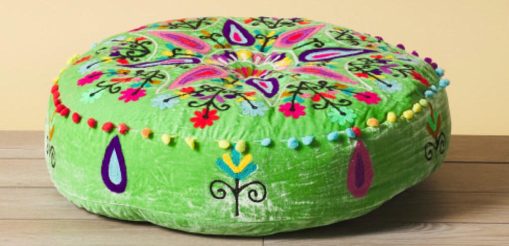 green embroidered circle pillow