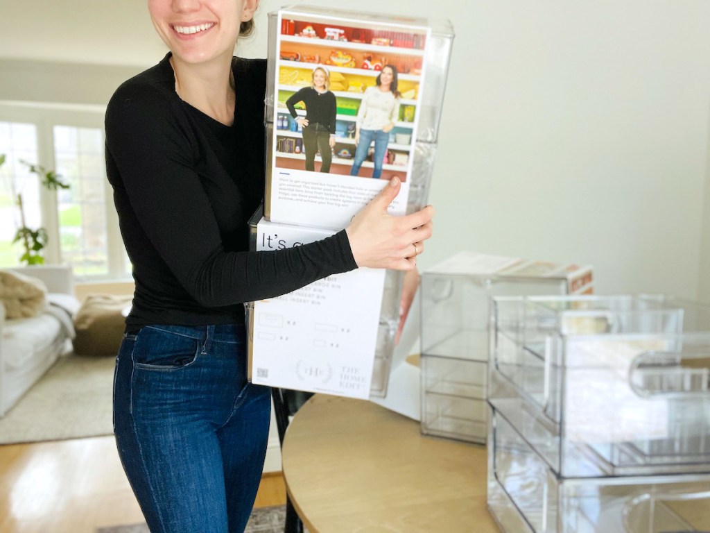 woman holding stacks of home edit walmart organizers