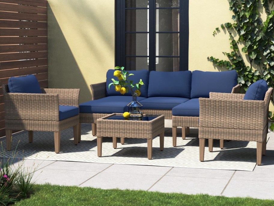 brown wicker patio furniture set with sofa, chairs, coffee table and blue cushions