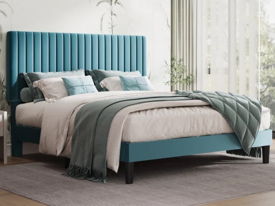 blue upholstered platform bed in a bedroom