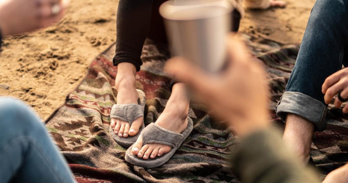 woman on blanket on beach wearing slippers