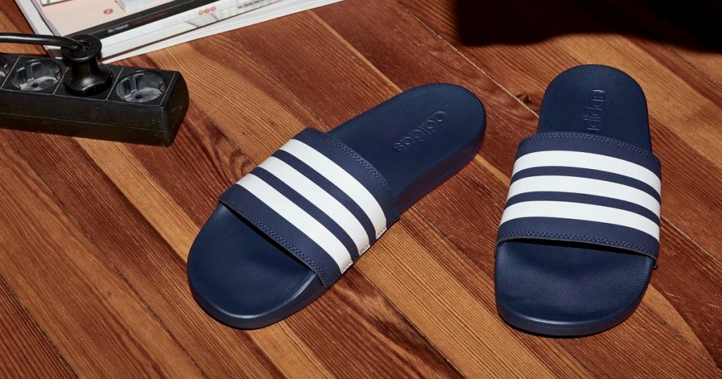 pair of dark blue slide sandals with white stripes