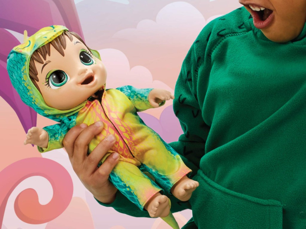 baby playing with green dinosaur baby doll