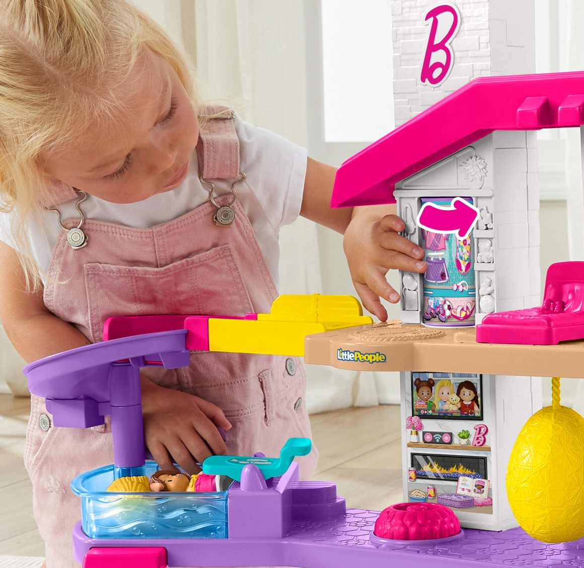 girl playing with a Barbie Little People house