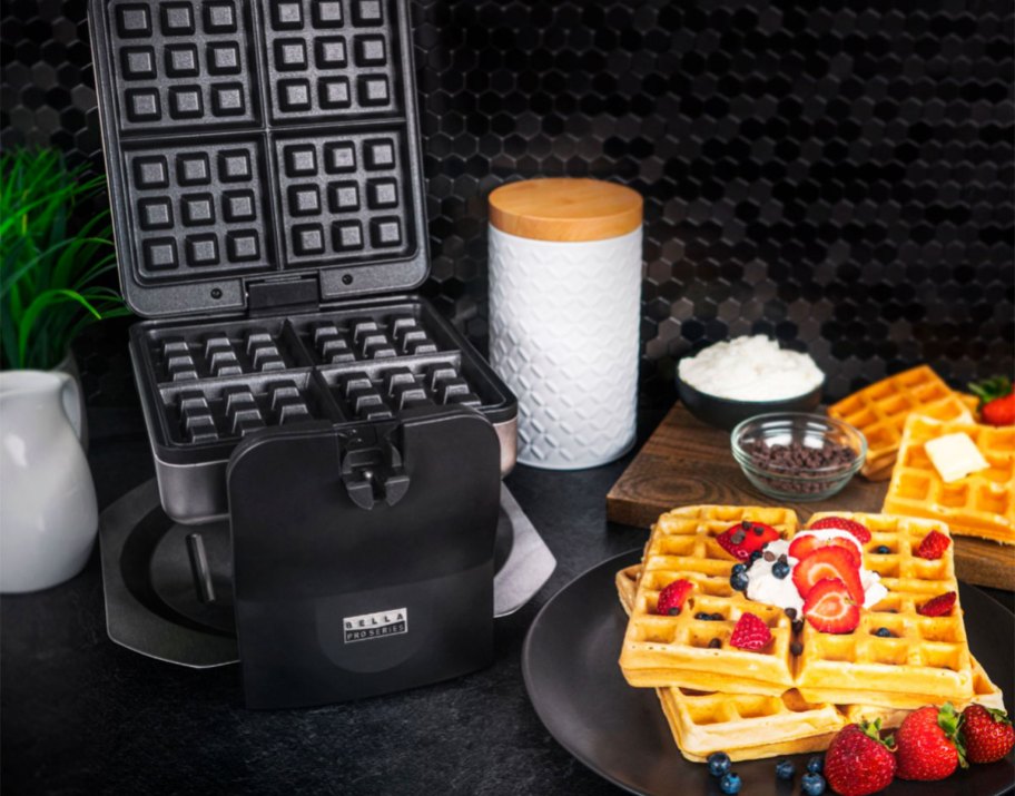 waffles with berries next to waffle maker