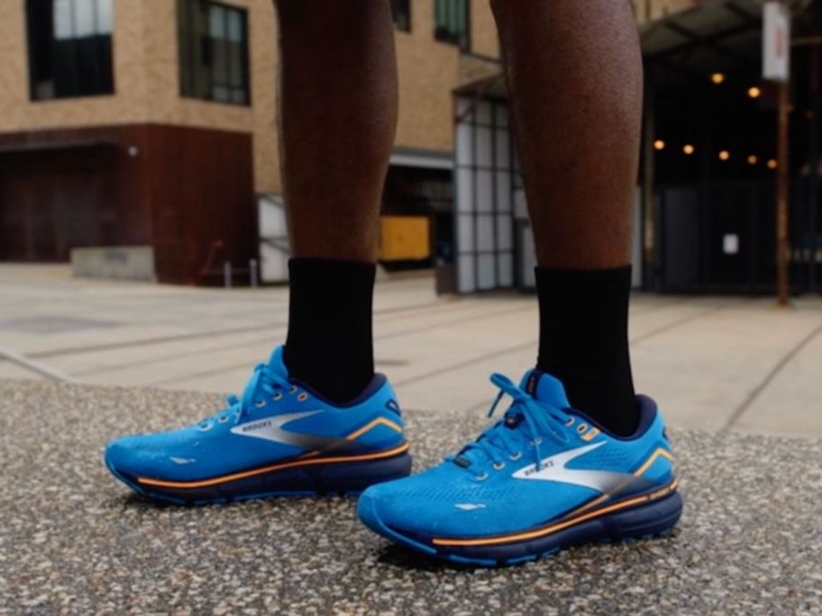Man's feet wearing Brooks Men's Ghost 15 GTX Waterproof Neutral Running Shoe on pavement
