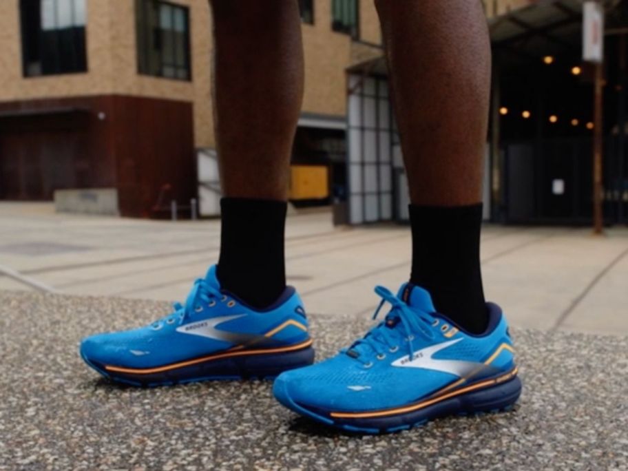 Man's feet wearing Brooks Men's Ghost 15 GTX Waterproof Neutral Running Shoe on pavement