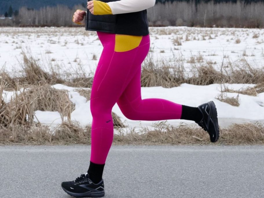 woman running on a road wearing Brooks Men's Ghost 15 GTX Waterproof Neutral Running Shoe 