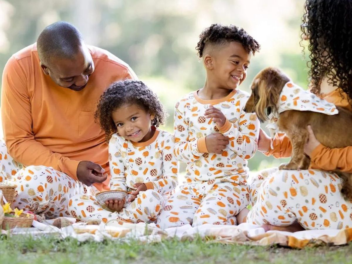 family wearing matching Thanksgiving pajamas having picnic