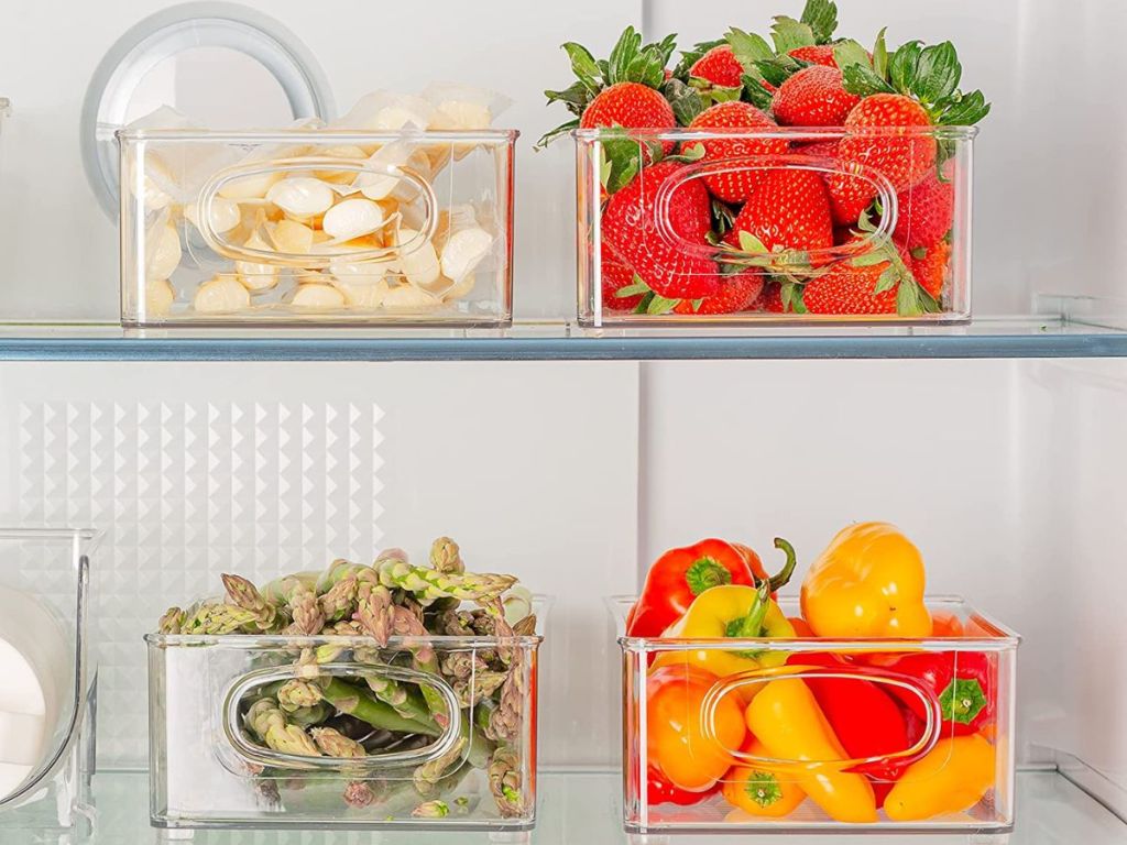 Plastic storage bins in a fridge with food in them