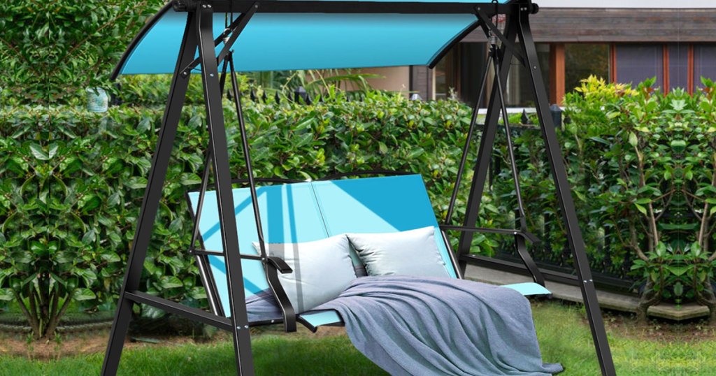 blue patio swing with pillows and blanket