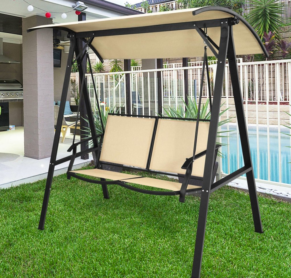 tan patio swing on grass near pool