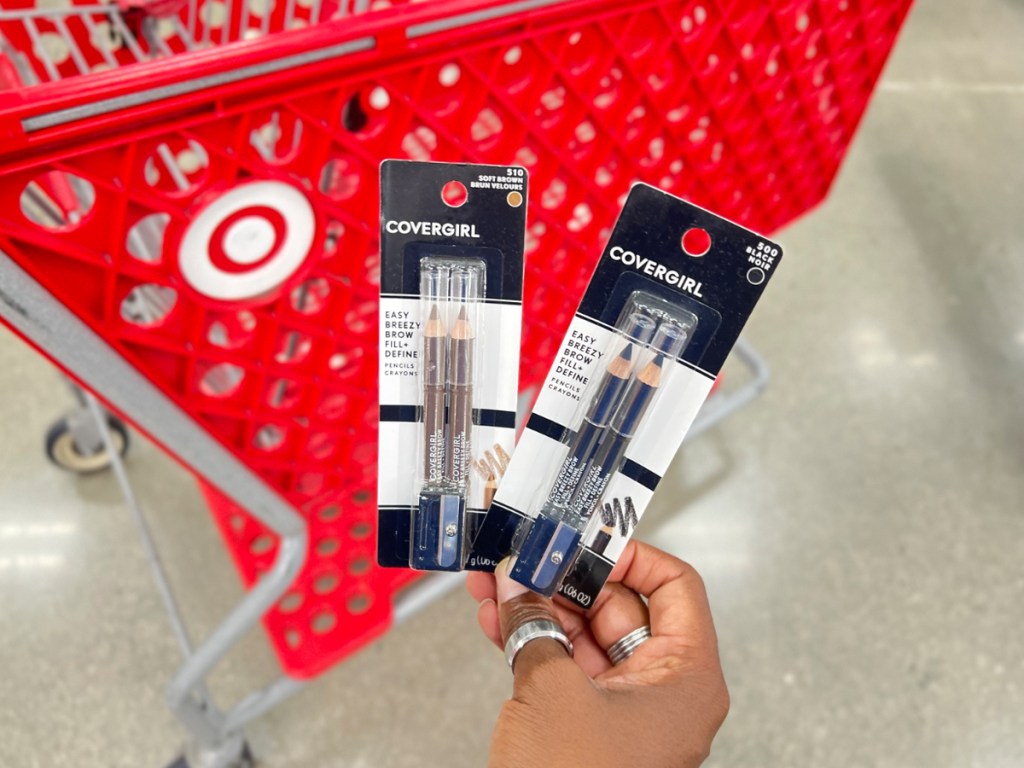 holding covergirl brow pencils in front of target shopping cart