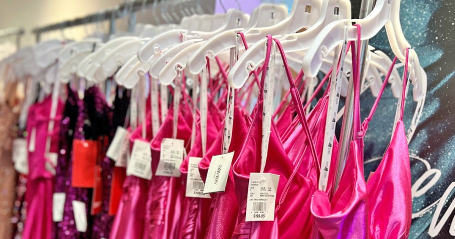 row of formal dresses on hangers on store display rack