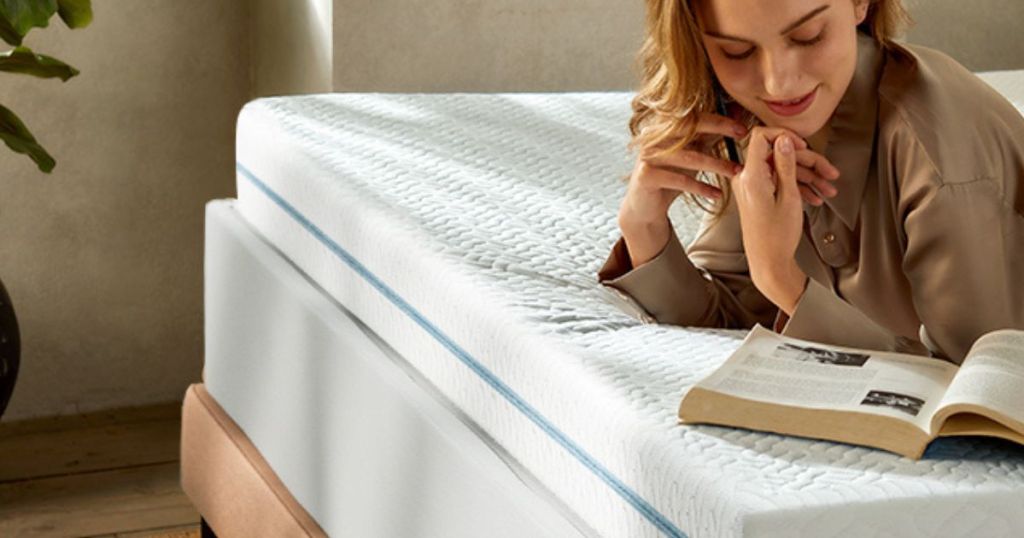 woman reading on a bed with a Dreamsmith Memory Foam Mattress Topper