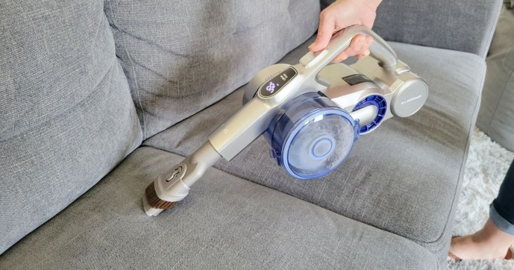 person using cordless vacuum attachment on couch 