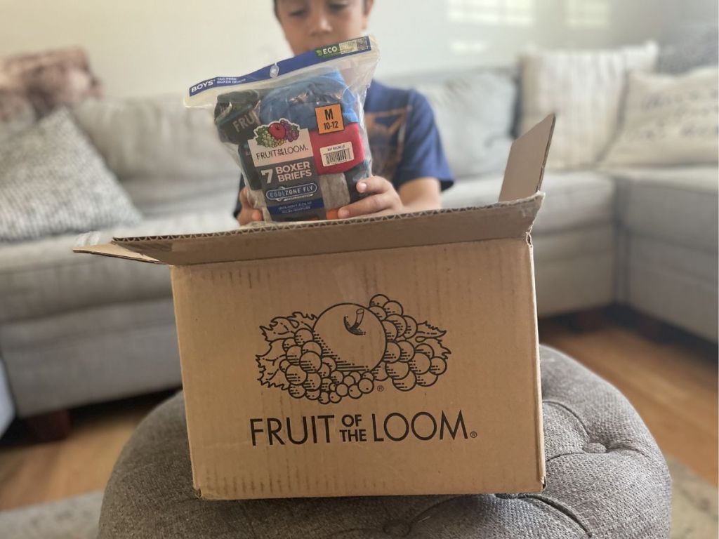boy taking pack of boys boxer briefs from Fruit of the Loom box