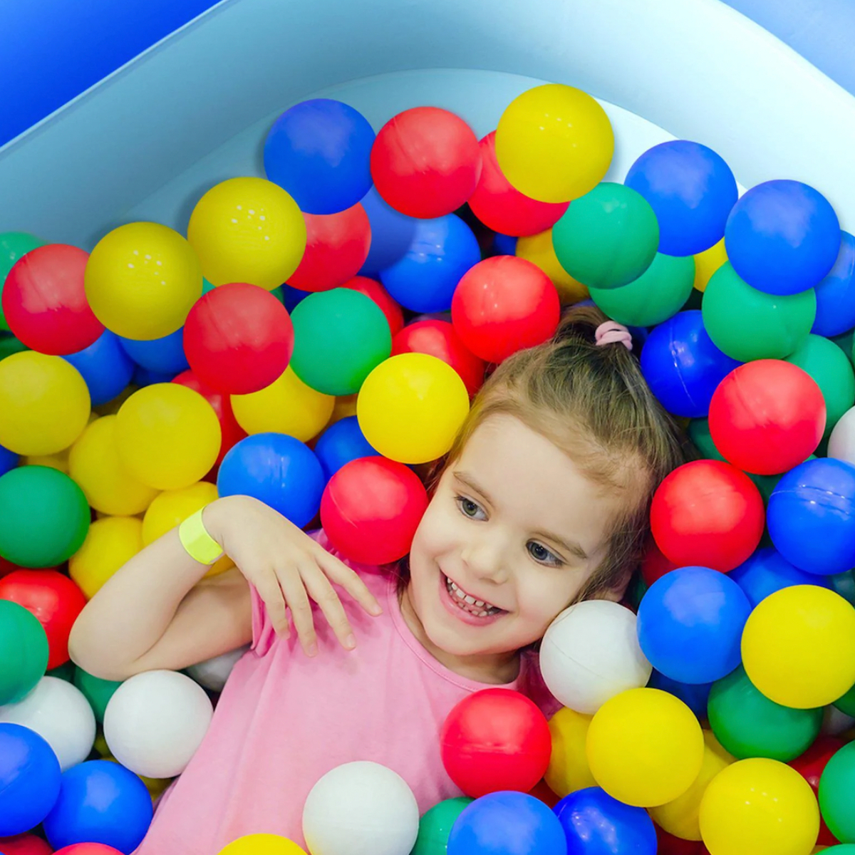 Girl playing in swimming pool ball pit