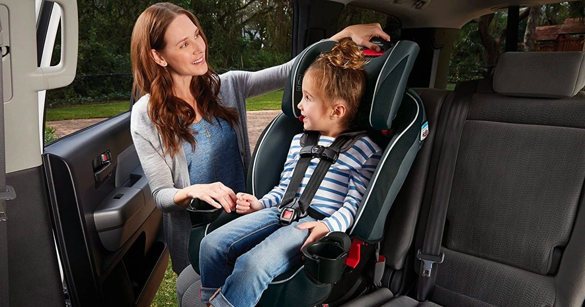 a woman putting a kid in a Graco slimfit car seat 3n1