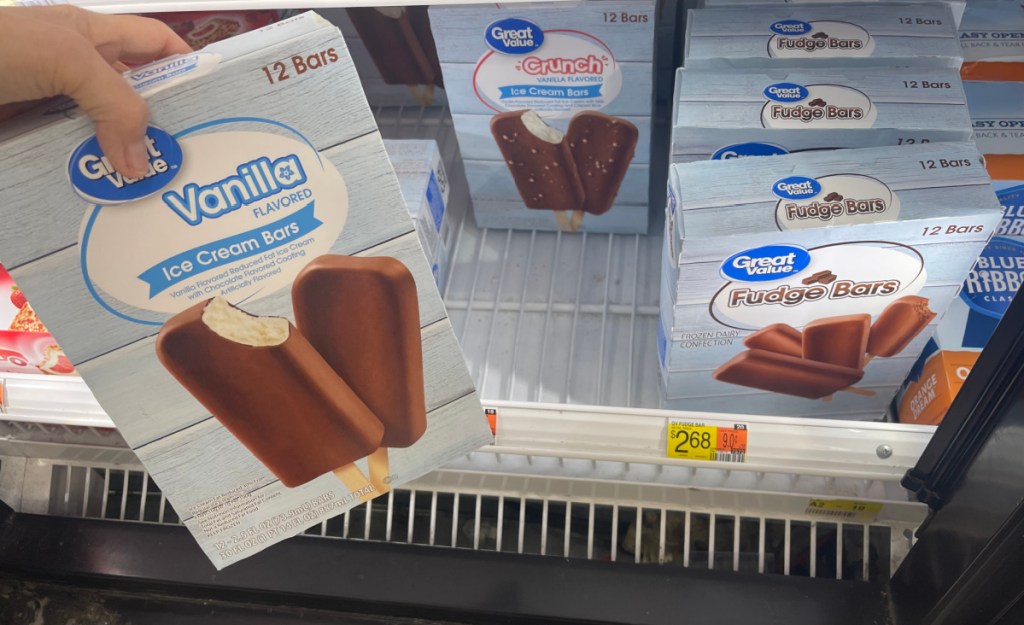 woman pulling a package of great value ice cream bars out of the store freezer