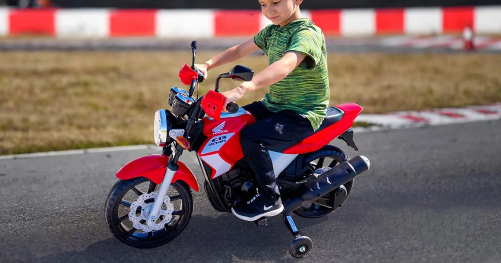 boy riding red and black motorcycle ride-on toy