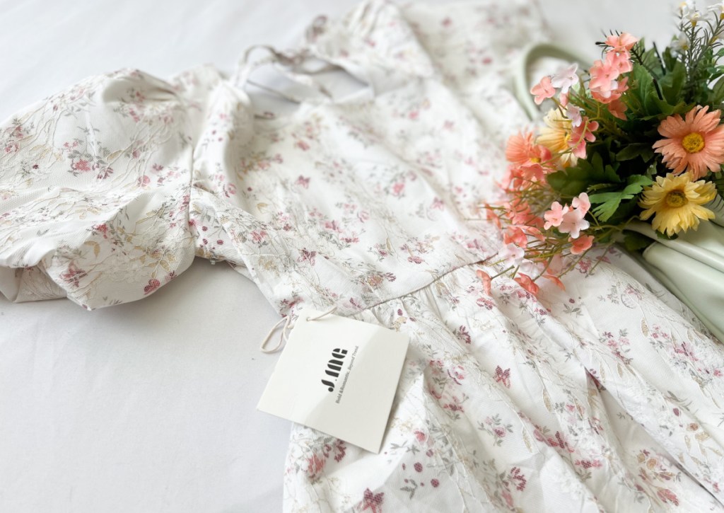 white floral dress next to flowers