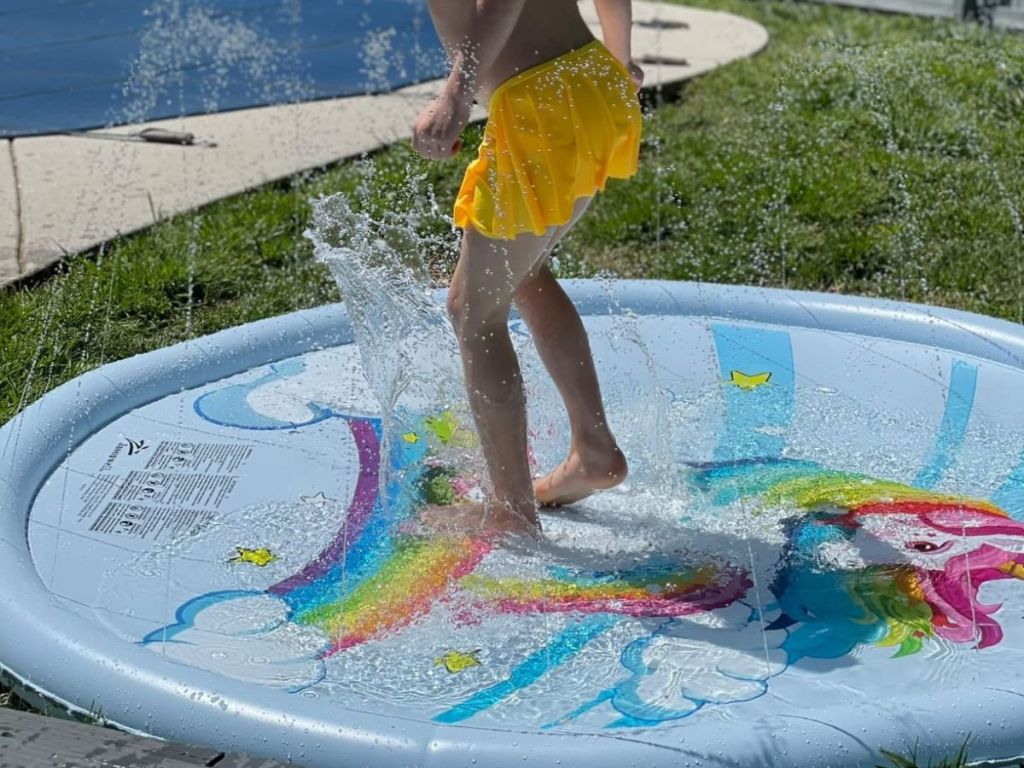 Child jumping on a Jasonwell Unicorn Splash Pad