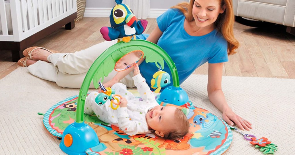 mother with baby laying on Little Tikes Gym