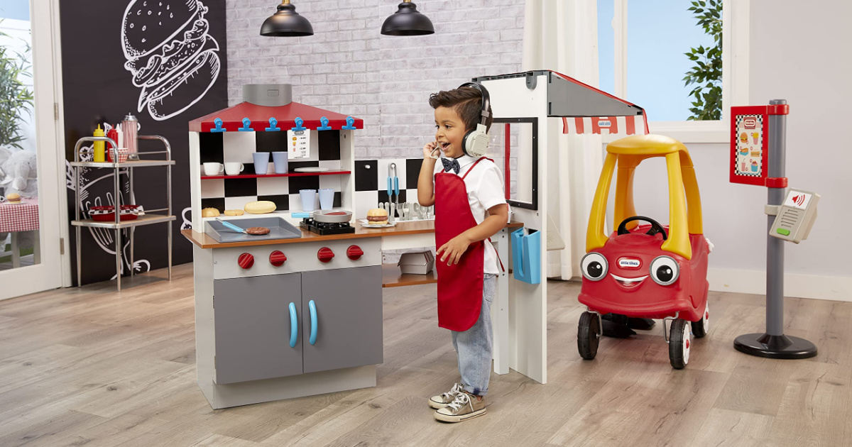 boy speaking into headset playing with diner drive-thru playset