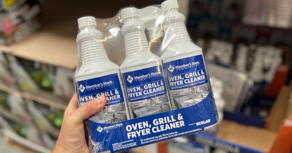 hand holding 3-count of oven cleaner bottles