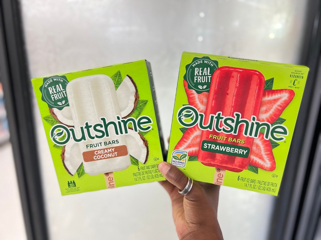 hand holding two boxes of Outshine Fruit Bars