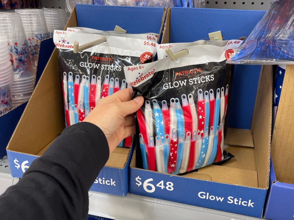 person holding package of Patriotic Glow Sticks in Walmart store