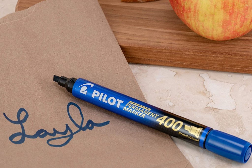 Pilot marker laying next to lunch brown paper bag