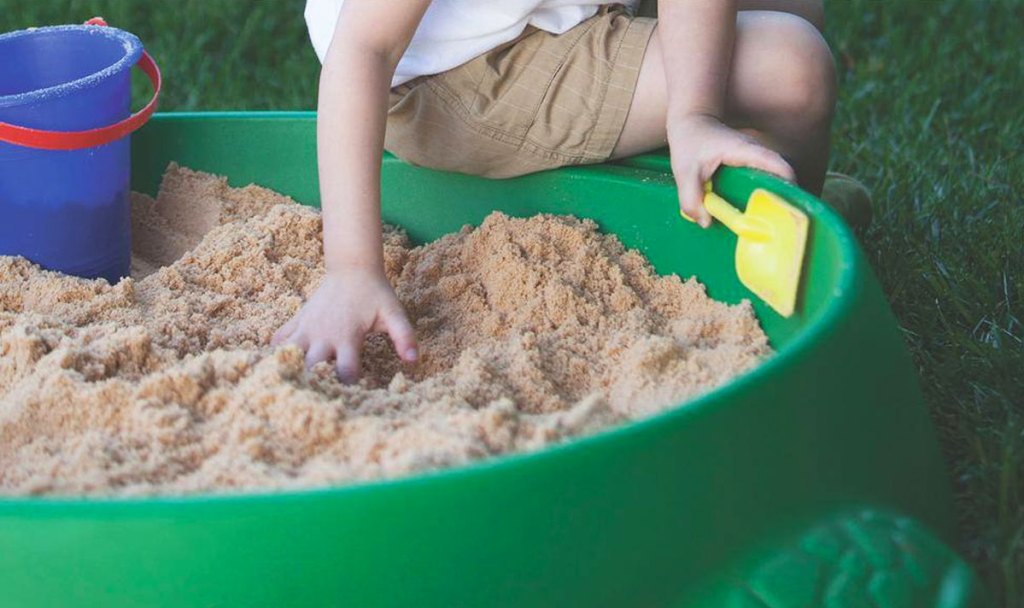 boy playing in sand box