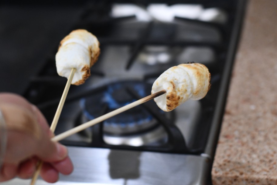 two roasted marshmallows on skewers