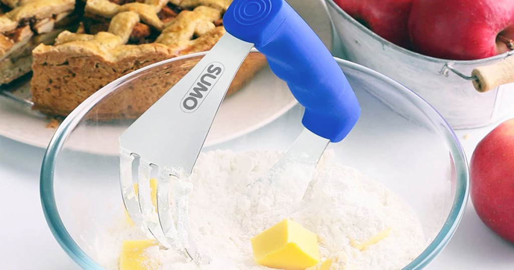 pastry cutter with blue handle in bowl of flour and butter