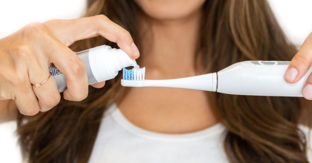 woman putting Smileactives Mega-Size Power Teeth Whitening Gel on toothbrush