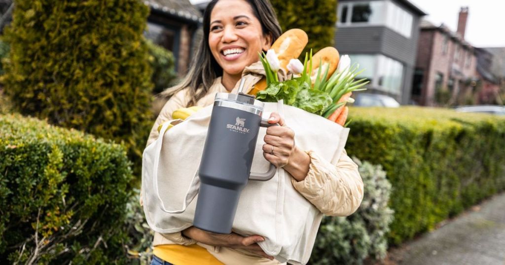 woman carrying a Stanley Quencher and groceries