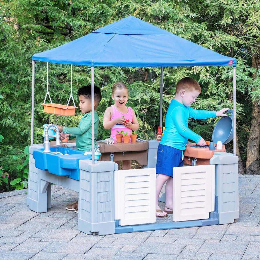 3 kids playing in the step2 grill and gather play center
